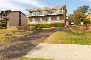 a large brick house with a balcony on a driveway at Boutique by Jervis Bay by Experience Jervis Bay in Vincentia