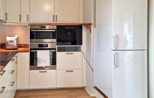 cocina con armarios blancos y nevera en Amazing Home In Spangereid With Wifi And 5 Bedrooms, en Spangereid