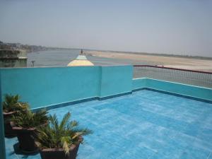 a blue swimming pool with a view of the beach at Kedareswar B&B in Varanasi