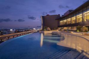 una piscina en la parte superior de un edificio por la noche en Asawin Grand Convention Hotel en Bangkok
