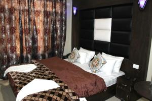 a bedroom with a bed with a black headboard at Hotel Samar in Srinagar