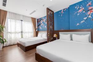 a bedroom with two beds and a blue wall at Smeraldo Hotel & Apartment in Da Nang