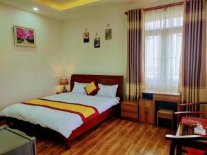 um quarto com uma cama e uma janela em NHÀ GÓC PHỐ Đà Lạt em Da Lat