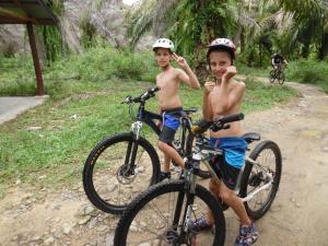 two young boys are posing with their bikes at AMBOW Homestay Jungle Trekking & Village Tour in Bukit Lawang +55 photos