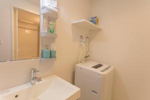 a bathroom with a sink and a toilet and a mirror at Tokyo Sunshine Tower Premium in Tokyo