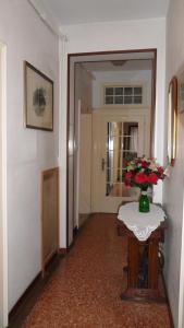 a hallway with a table with a vase of flowers on it at Hotel Locanda Ca' Foscari in Venice