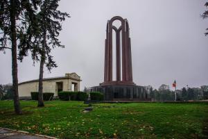 a monument in a park with a building and trees at Between Parks - King Bed - Central - Football field in Bucharest