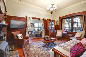 uma sala de estar com um sofá e uma mesa em Kings Bower em Katoomba