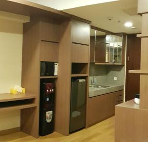 a kitchen with a black refrigerator and a sink at U Residence Tower2 Supermal Lippo Karawaci in Klapadua