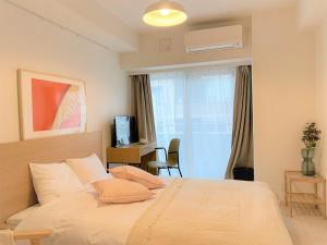 um quarto com uma cama, uma secretária e uma janela em Tokyo Sunshine Tower Premium em Tóquio