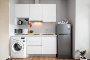 a kitchen with a refrigerator and a washing machine at The Coast Bangkok Skywalk to BTS & BITECH Bangna in Bangna