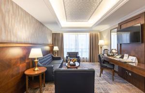 a hotel room with a desk and a living room at MADEN Hotel in Medina