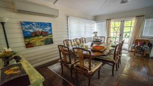 a dining room with a wooden table and chairs at Rose Pine Cottage at Leura in Leura