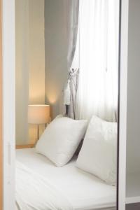 a bedroom with a bed with white pillows and a window at Wesa Home Place in Khon Kaen