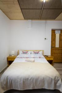 a bedroom with a large white bed with a wooden ceiling at Pensiunea Novac in Durau