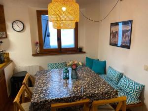 una sala da pranzo con tavolo, sedie e orologio di Gessa bonita casa junto a Baqueira DREAM a Gessa