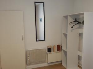 a bathroom with a mirror on the wall and a shelf at SAINT MALO bel appartement plain pied 300 m gare prés plage du sillon Intramuros a pied in Saint Malo