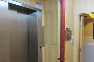 a elevator in a bathroom with a red pole at Wai fan Guest house in Hong Kong