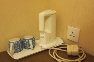 a white mixer and two cups on a counter at Wai fan Guest house in Hong Kong