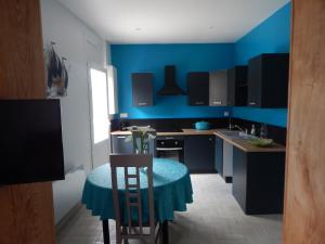 cocina azul con mesa y pared azul en SAINT MALO bel appartement plain pied 300 m gare prés plage du sillon Intramuros a pied, en Saint-Malo