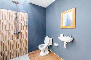 a bathroom with a shower and a toilet and a sink at The Box House in Nusa Penida