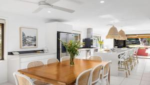 a dining room and kitchen with a wooden table and chairs at Shoal Bay Oasis in Shoal Bay
