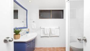 a white bathroom with a sink and a toilet at Shoal Bay Oasis in Shoal Bay