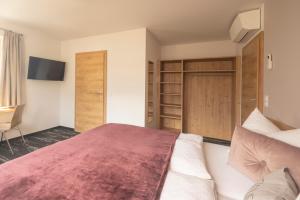 1 dormitorio con 1 cama grande y TV en good-goisern hotel en Bad Goisern