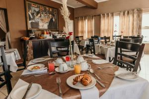 a dining room with a table with food on it at Artemis Hotel Swakopmund in Swakopmund