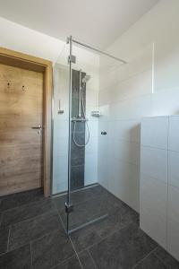 a shower with a glass door in a bathroom at good-goisern hotel in Bad Goisern