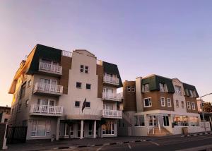 a row of apartment buildings on a street at Artemis Hotel Swakopmund in Swakopmund