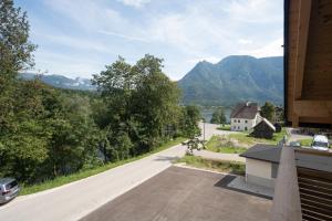 un camino vacío con una casa y montañas en el fondo en good-goisern hotel en Bad Goisern