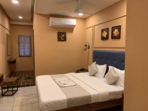 1 dormitorio con 1 cama con cabecero azul en Hotel Radha krishna, en Anand