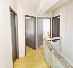 un pasillo con tres puertas y una persona caminando por él en Apartman 993, en Pale