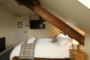 a bedroom with a bed with white sheets and a tv at The Avenue in Durham