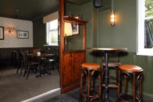 um bar com bancos e mesas de madeira num restaurante em The Avenue em Durham