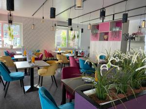 un restaurante con sillas y mesas coloridas y mesa en Hotel Gasthof Zur Post, en Cuxhaven