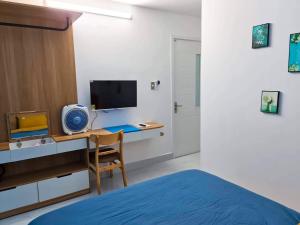 a bedroom with a desk with a computer and a bed at EURO HOUSE in Da Lat