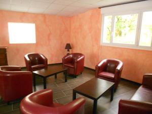 - une salle d'attente avec des chaises, des tables et une fenêtre dans l'établissement Hotel Les Sapins, à Gérardmer