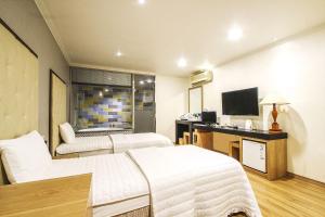 a hotel room with two beds and a television at Central Hotel in Changwon