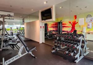 a gym with several tread machines and a wall mural at Holiday Inn Express Pattaya Central, an IHG Hotel in Pattaya