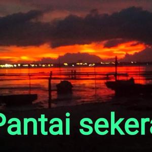 un coucher de soleil sur l'eau avec les mots parcialisen dans l'établissement Homestay Pak Ucu, 