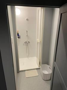 a small bathroom with a shower with a mirror at Beppu hostel&cafe ourschestra in Beppu