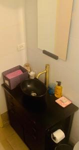 baño con lavabo negro y espejo en Private Room Studio Suite Jerusalem, en Jerusalén