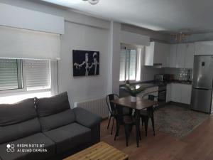 a living room with a couch and a table and a kitchen at Aparramento Rosa in Murcia