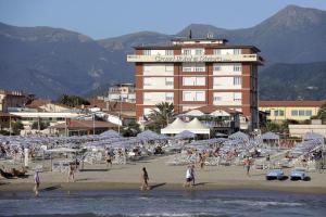 a group of people on a beach with a hotel at Grand Hotel & Riviera in Lido di Camaiore
