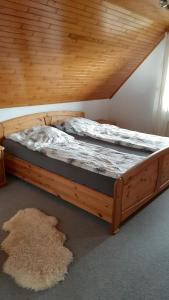 twee bedden in een kamer met een houten plafond bij Ferienwohnung Langfeld in Kronsgaard