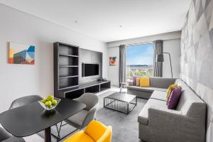 a living room with a couch and a table at Studio M Arabian Plaza Hotel & Hotel Apartments in Dubai