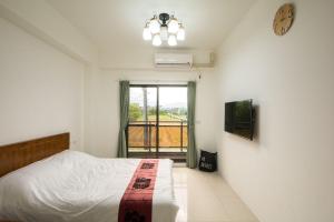 ein Schlafzimmer mit einem Bett und einer Uhr an der Wand in der Unterkunft Chang Hiong Homestay in Yilan