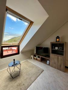 sala de estar con ventana grande y mesa en Ático con vistas a la ría y a la montaña en Unquera, en Unquera